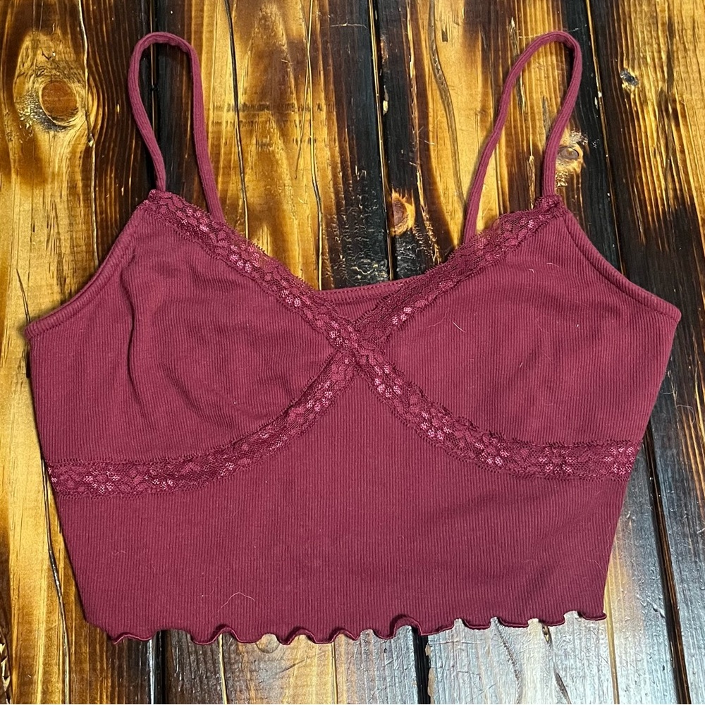 Burgundy crop tank top with with flower lace accents and lettuce trimming.